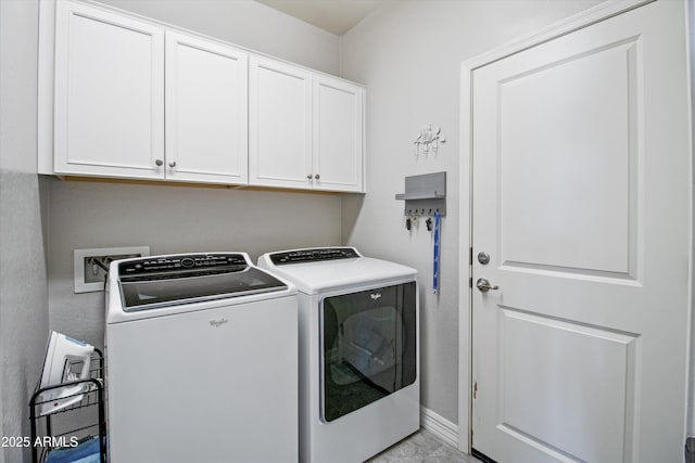 laundry area with baseboards, cabinet space, and washing machine and clothes dryer