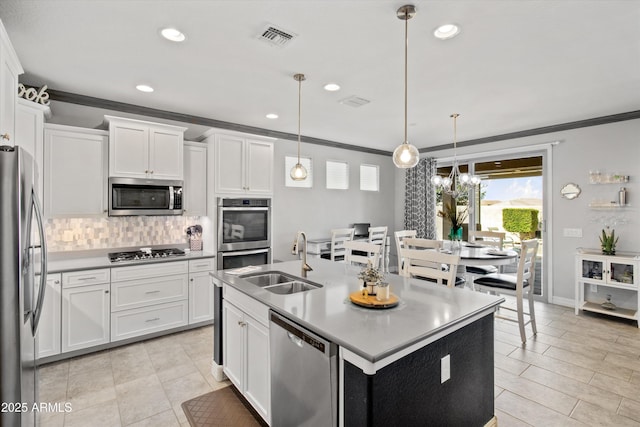 kitchen with visible vents, crown molding, tasteful backsplash, a sink, and stainless steel appliances