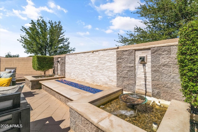 view of patio / terrace featuring a fenced backyard and a fire pit