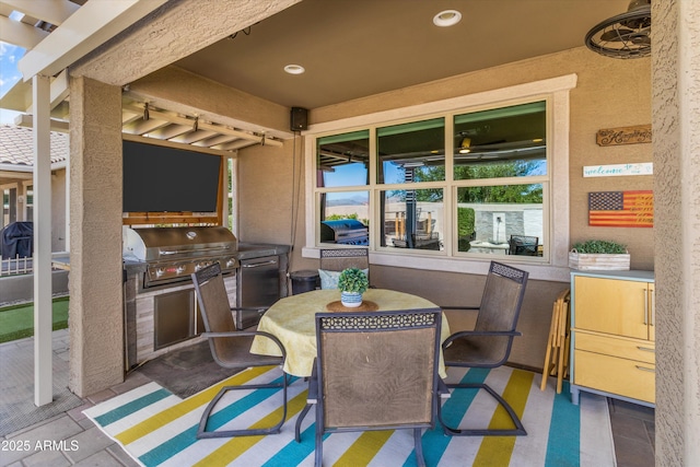 view of patio with an outdoor kitchen, outdoor dining space, and area for grilling