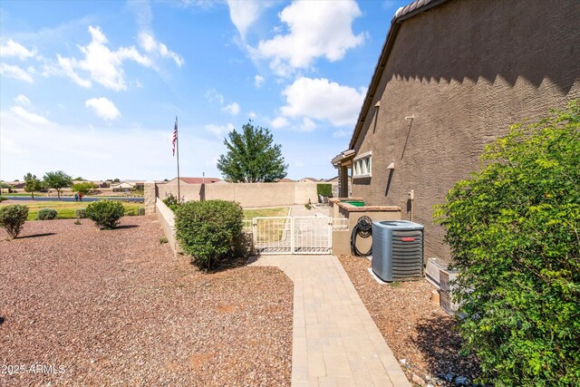 view of yard featuring a gate, central AC, and fence