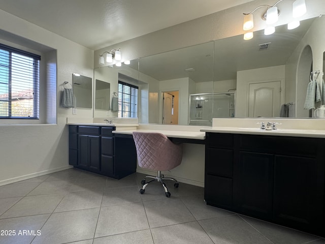 bathroom with visible vents, two vanities, a stall shower, a sink, and tile patterned flooring