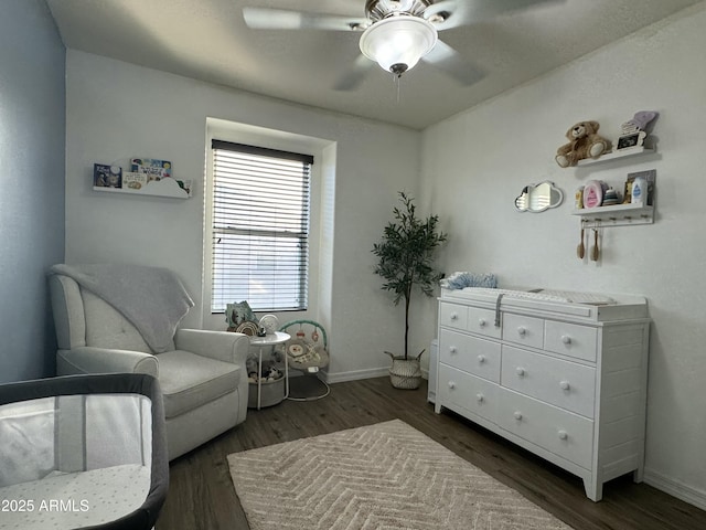 sitting room featuring dark wood finished floors, baseboards, and a ceiling fan