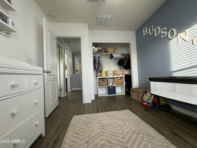 bedroom featuring a closet, visible vents, and dark wood-type flooring