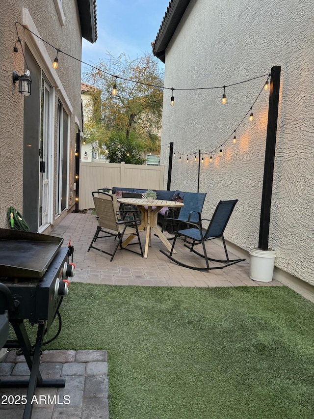 view of patio with outdoor dining area, fence, and grilling area