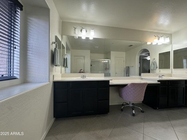 full bath featuring a sink, two vanities, a stall shower, and tile patterned flooring