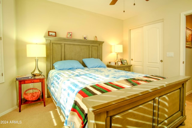 bedroom with light colored carpet, ceiling fan, and a closet