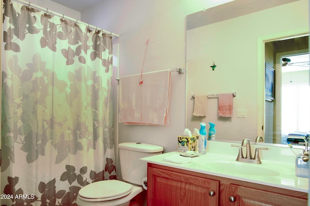 bathroom featuring a shower with shower curtain, vanity, and toilet