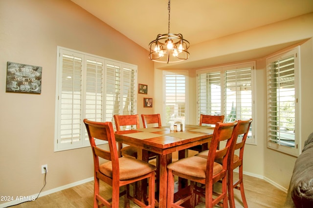 dining room with light hardwood / wood-style floors, vaulted ceiling, and a healthy amount of sunlight