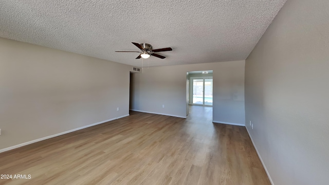 spare room featuring ceiling fan, light hardwood / wood-style flooring, and a textured ceiling