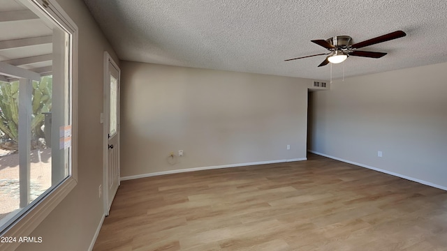 empty room with ceiling fan, a textured ceiling, and light hardwood / wood-style flooring