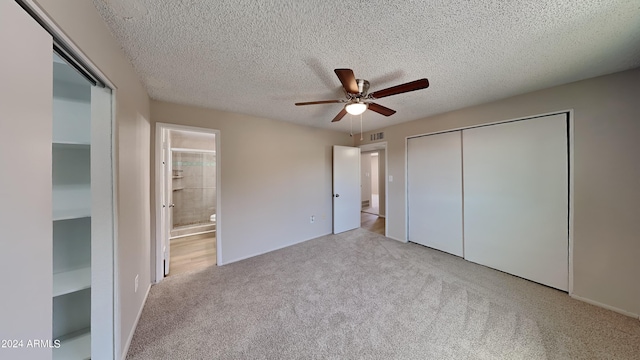 unfurnished bedroom with a textured ceiling, ceiling fan, ensuite bathroom, and light carpet