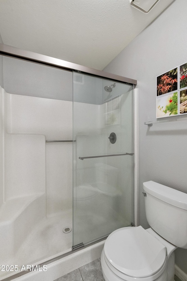 bathroom featuring toilet, an enclosed shower, and tile patterned flooring