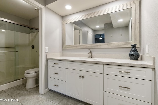 bathroom with a shower with door, vanity, tile patterned flooring, and toilet