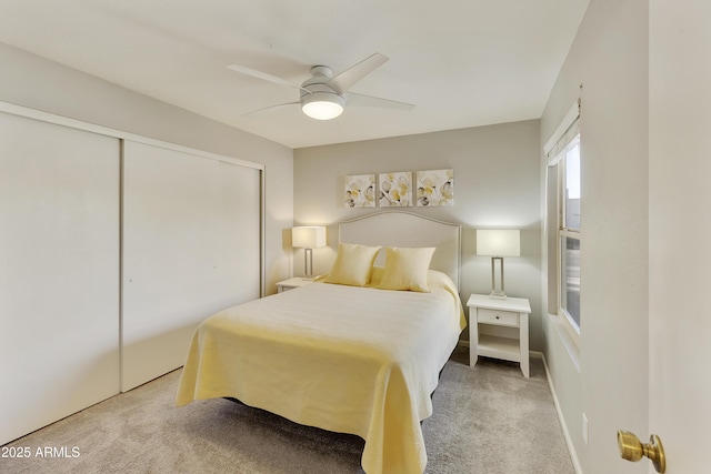 bedroom with light carpet, ceiling fan, and a closet