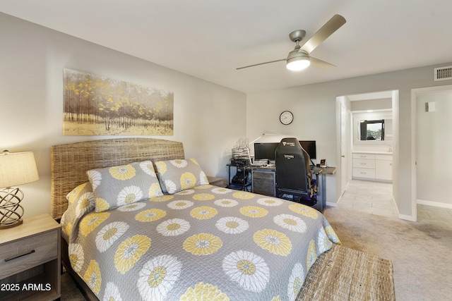 bedroom featuring ceiling fan, light colored carpet, and ensuite bathroom