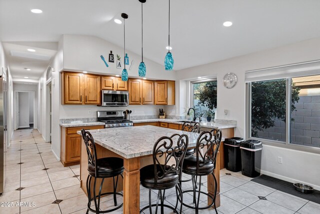 4493 E Desert Sands Dr, Chandler, AZ 85249 - kitchen featuring stainless steel appliances, a sink, light tile patterned floors, lofted ceiling, and brown cabinets