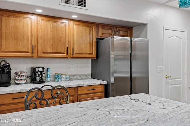 4493 E Desert Sands Dr, Chandler, AZ 85249 - kitchen with freestanding refrigerator, brown cabinets, and light stone counters