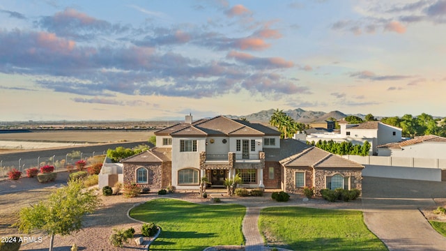 mediterranean / spanish home featuring a mountain view and a lawn