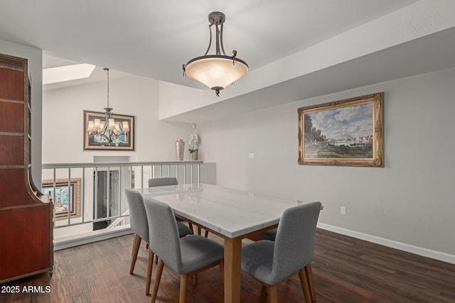 dining area featuring lofted ceiling with skylight, dark wood-style flooring, baseboards, and an inviting chandelier