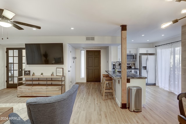 living room featuring french doors, light wood-type flooring, and ceiling fan