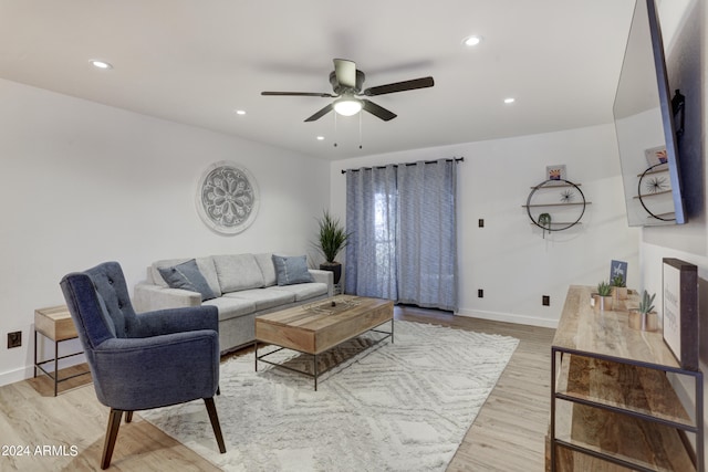 living room featuring light hardwood / wood-style flooring and ceiling fan