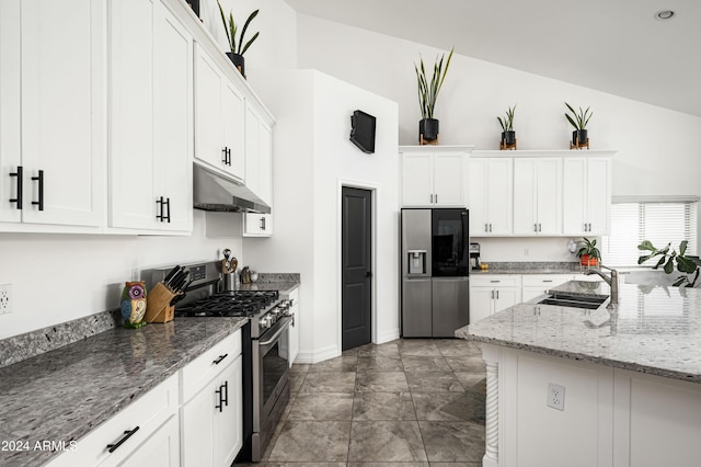 kitchen with light stone countertops, appliances with stainless steel finishes, dark tile patterned floors, sink, and white cabinetry