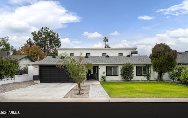 view of front of house featuring a garage and a front lawn