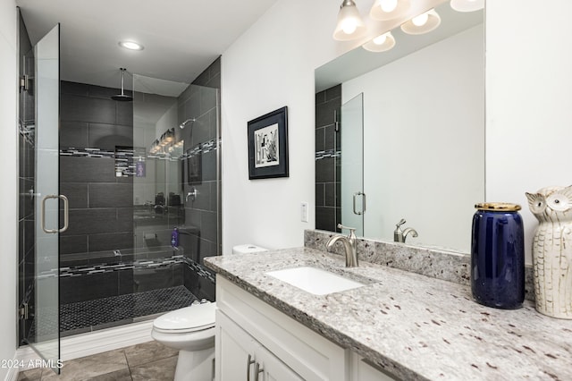 bathroom with tile patterned floors, walk in shower, vanity, and toilet