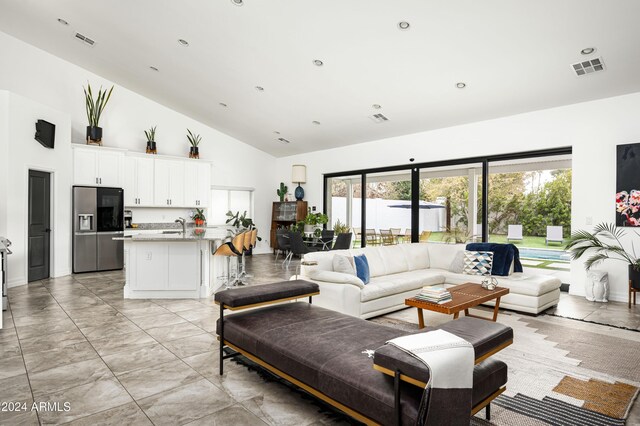 living room featuring sink and high vaulted ceiling