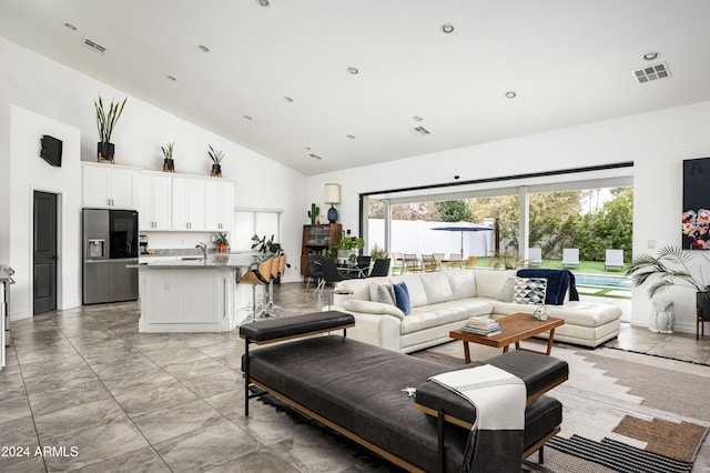 living room with sink and high vaulted ceiling