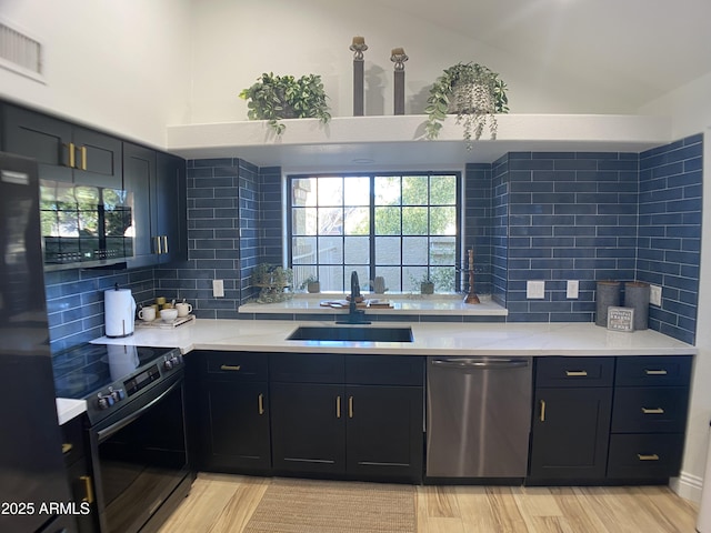 kitchen with electric stove, backsplash, light hardwood / wood-style floors, stainless steel dishwasher, and sink