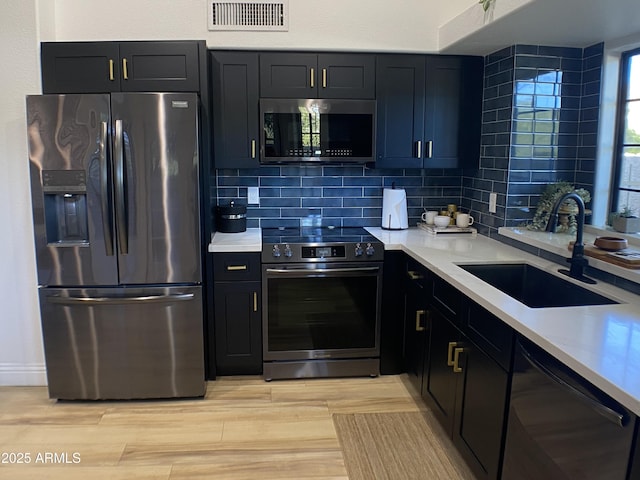 kitchen featuring stainless steel appliances, backsplash, and sink