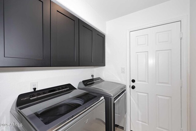 laundry room featuring washing machine and clothes dryer and cabinets