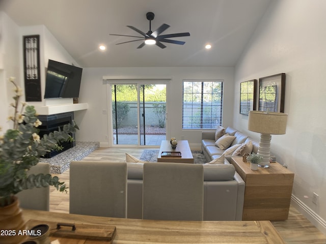 living room with ceiling fan, hardwood / wood-style floors, and lofted ceiling