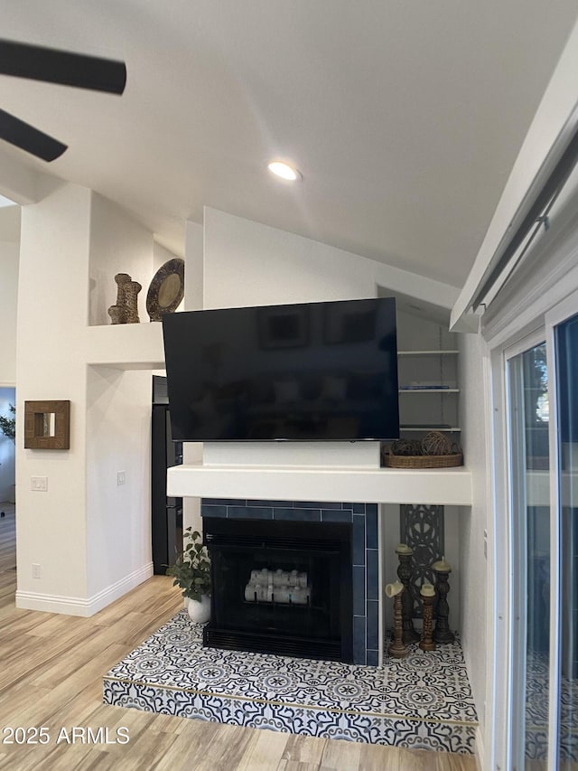 details with ceiling fan, hardwood / wood-style floors, and a tile fireplace