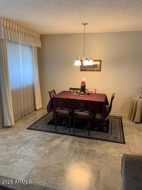 dining room featuring an inviting chandelier and a textured ceiling