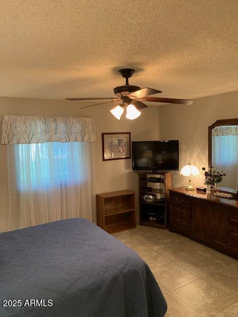 bedroom with a textured ceiling and ceiling fan