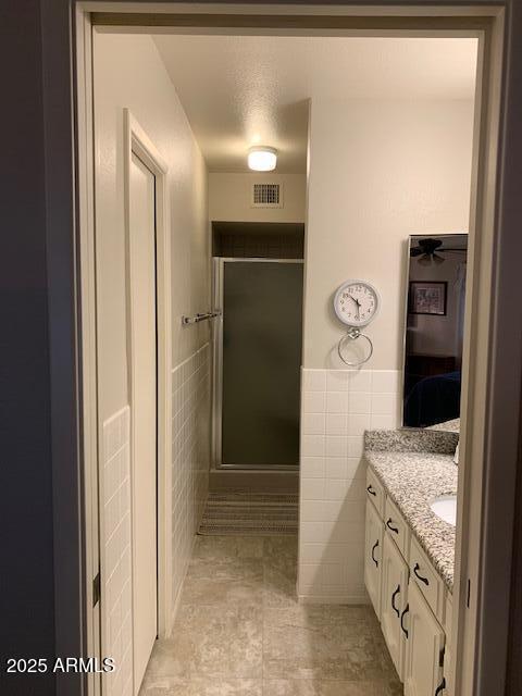 bathroom featuring tile walls, vanity, and ceiling fan