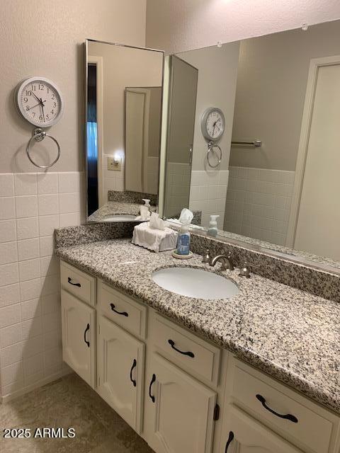 bathroom featuring tile patterned floors, vanity, and tile walls