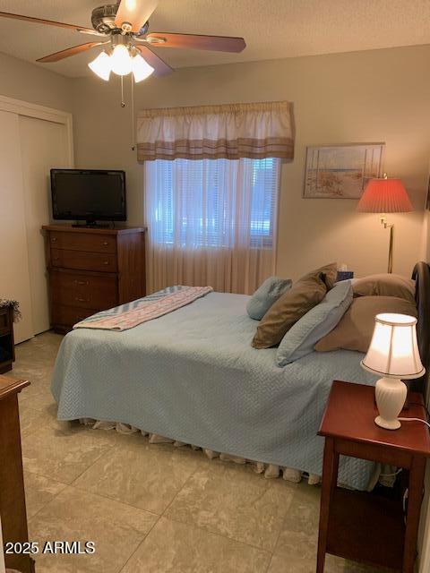 bedroom with a textured ceiling, a closet, and ceiling fan