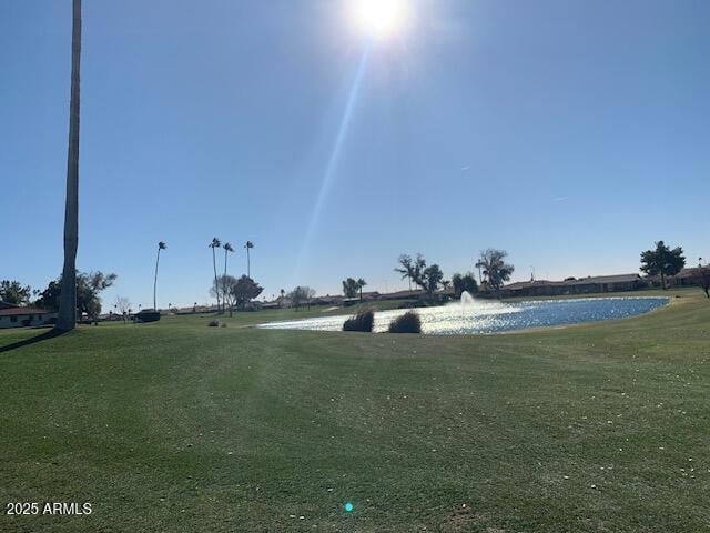 view of property's community with a lawn and a water view