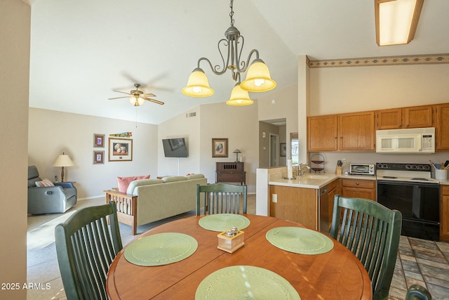 dining room featuring sink, ceiling fan with notable chandelier, and high vaulted ceiling