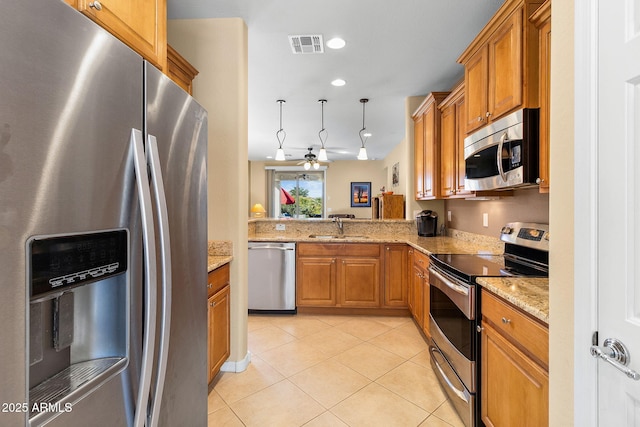 kitchen featuring pendant lighting, stainless steel appliances, sink, light tile patterned flooring, and ceiling fan