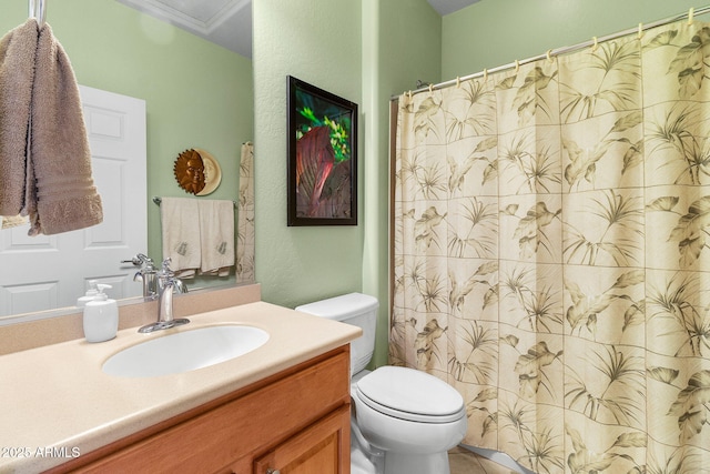 bathroom with toilet, vanity, and ornamental molding