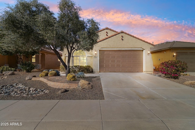 view of front of property with a garage, concrete driveway, a tiled roof, and stucco siding