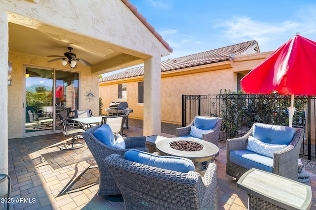 view of patio with ceiling fan, a grill, and a fire pit