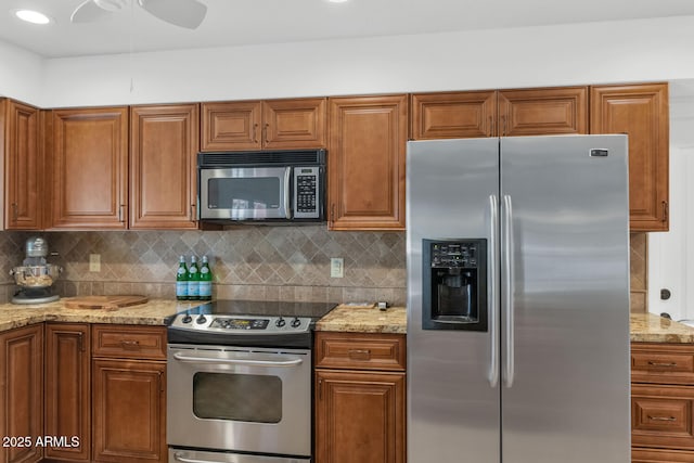 12682 N 80th Pl, Scottsdale, AZ 85260 - kitchen featuring appliances with stainless steel finishes, brown cabinetry, and decorative backsplash
