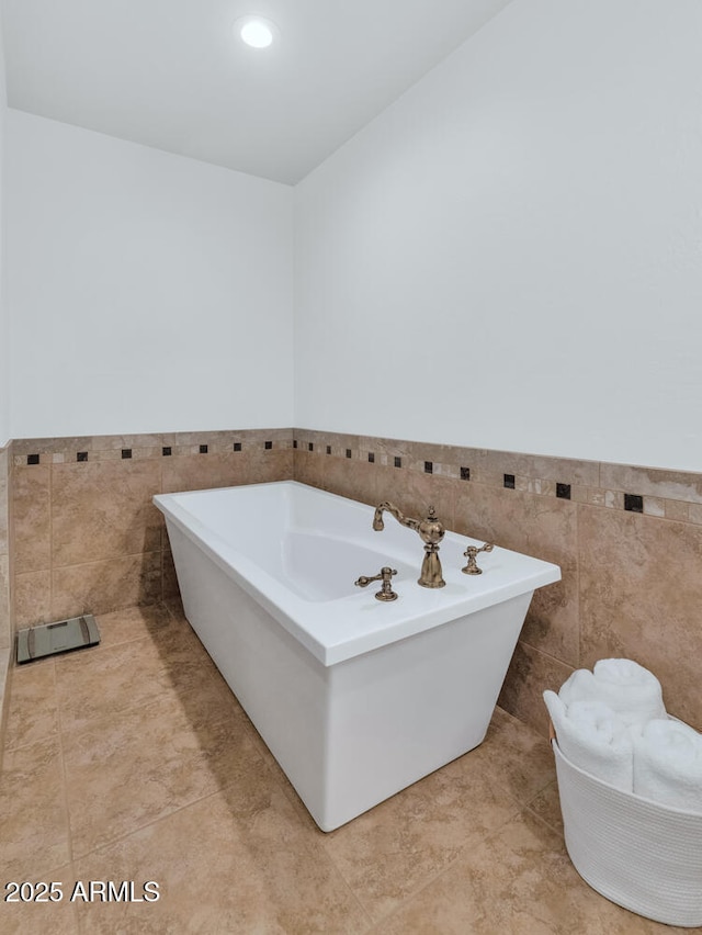 12682 N 80th Pl, Scottsdale, AZ 85260 - bathroom featuring tile walls, a freestanding bath, wainscoting, and tile patterned flooring