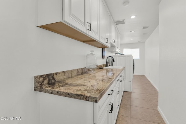 12682 N 80th Pl, Scottsdale, AZ 85260 - kitchen with white cabinets, light tile patterned floors, recessed lighting, and washing machine and clothes dryer